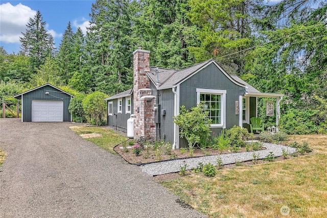 1400 Baby Doll Rd SE, Port Orchard, WA 98366 - view of front facade featuring a detached garage, an outbuilding, a chimney, and asphalt driveway