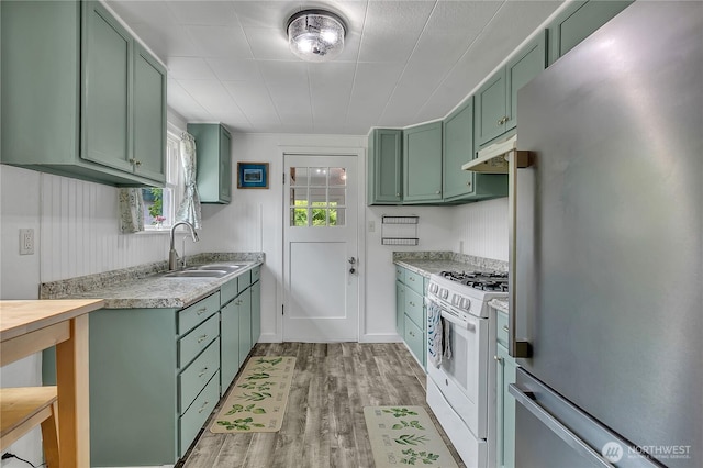 1400 Baby Doll Rd SE, Port Orchard, WA 98366 - kitchen featuring green cabinets, freestanding refrigerator, white gas range, under cabinet range hood, and light countertops