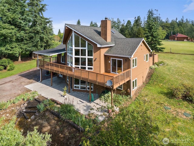 107 Gilbert Rd N, Onalaska, WA 98570 - back of house featuring a patio area, a wooden deck, a shingled roof, a chimney, and a lawn