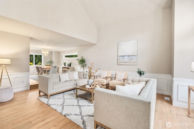 1514 232nd Pl SW, Bothell, WA 98021 - living room with a chandelier, wood finished floors, a wainscoted wall, a decorative wall, and high vaulted ceiling