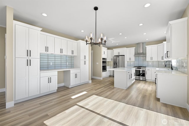 5513 Presley Ln, Ferndale, WA 98248 - kitchen with wall chimney range hood, appliances with stainless steel finishes, decorative backsplash, recessed lighting, and a center island