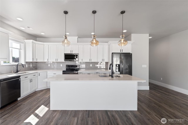 1300 W Marina Dr Unit 33, Moses Lake, WA 98837 - kitchen featuring stainless steel appliances, a kitchen island with sink, decorative backsplash, dark wood-style floors, and light countertops