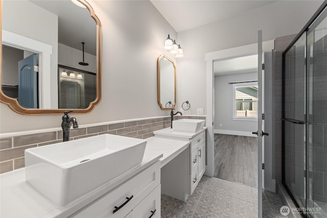 1300 W Marina Dr Unit 33, Moses Lake, WA 98837 - full bathroom featuring double vanity, tile walls, a tile shower, tile patterned floors, and wainscoting