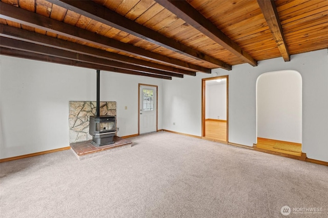 123 Scenic View Dr, Longview, WA 98632 - unfurnished living room featuring a wooden ceiling with exposed beams, carpet flooring, a wood stove, and arched walkways