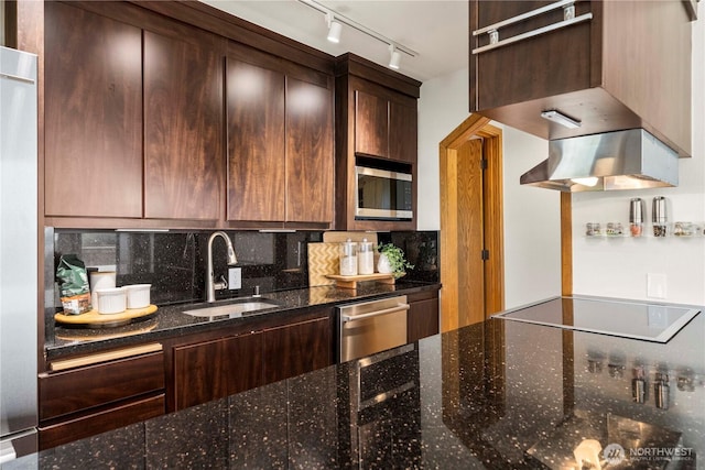 3519 N Union Ave Unit 2, Tacoma, WA 98407 - kitchen with stainless steel appliances, rail lighting, dark stone countertops, backsplash, and dark brown cabinets