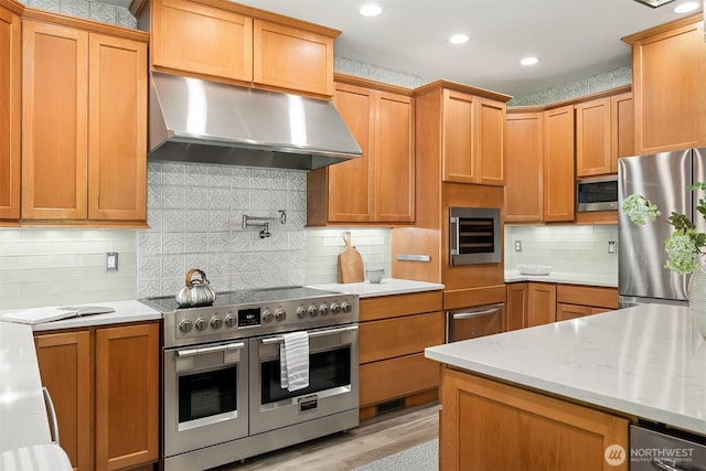 32701 SE 43rd St, Fall City, WA 98024 - kitchen featuring stainless steel appliances, wall chimney exhaust hood, tasteful backsplash, light wood-type flooring, and wine cooler
