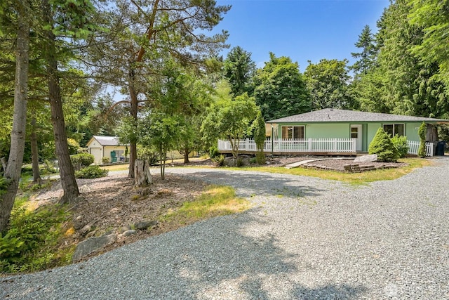 24 Makah Way, La Conner, WA 98257 - view of front of property featuring gravel driveway, covered porch, and stucco siding