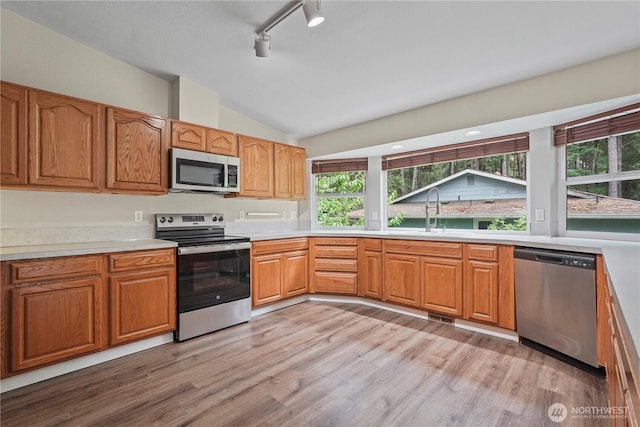 9910 Fairview Lake Rd SW, Port Orchard, WA 98367 - kitchen with stainless steel appliances, lofted ceiling, light wood-style flooring, light countertops, and rail lighting