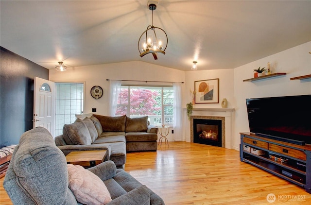 4031 Alyssa Ct, Bellingham, WA 98226 - living area with a chandelier, light wood-type flooring, vaulted ceiling, and a glass covered fireplace