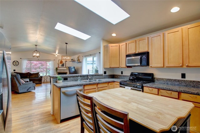 4031 Alyssa Ct, Bellingham, WA 98226 - kitchen with stainless steel appliances, light brown cabinetry, a peninsula, a skylight, and open floor plan