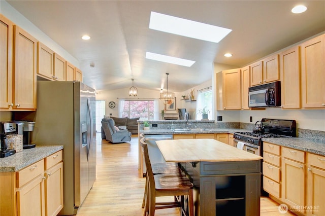 4031 Alyssa Ct, Bellingham, WA 98226 - kitchen featuring appliances with stainless steel finishes, light brown cabinets, light wood-type flooring, a peninsula, and lofted ceiling