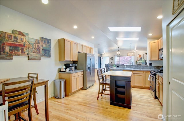 4031 Alyssa Ct, Bellingham, WA 98226 - kitchen with appliances with stainless steel finishes, lofted ceiling, light brown cabinetry, a skylight, and light wood-style floors