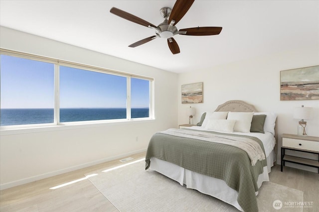 2369 W Beach Rd, Oak Harbor, WA 98277 - bedroom with a water view, wood finished floors, and ceiling fan