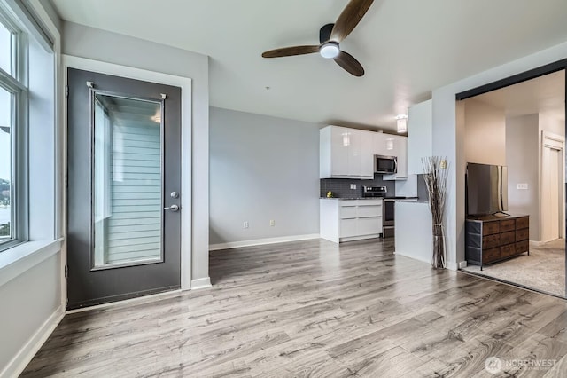 655 Crockett St Unit B304, Seattle, WA 98109 - kitchen with stainless steel appliances, white cabinetry, ceiling fan, and light wood finished floors
