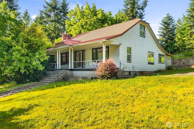 212 SE Cowlitz Rd, Winlock, WA 98596 - view of front facade with a porch, a metal roof, a chimney, and a front lawn