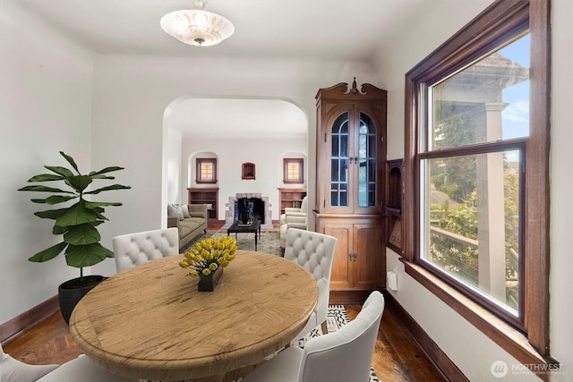 720 N Forest St, Bellingham, WA 98225 - dining room with a fireplace, arched walkways, and dark wood finished floors