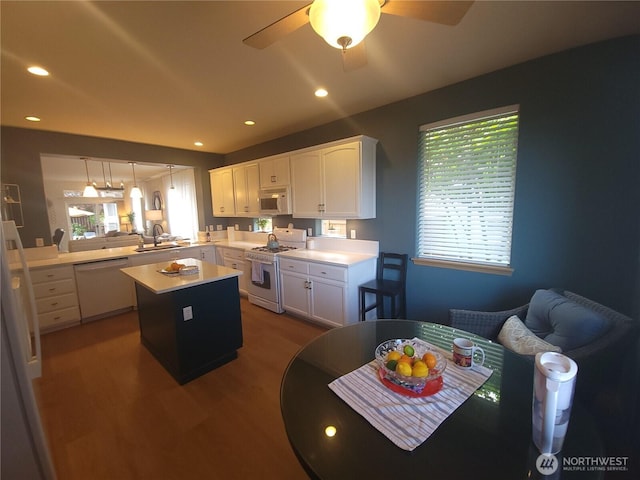 8542 Bainbridge Loop NE, Lacey, WA 98516 - kitchen featuring white appliances, wood finished floors, a center island, light countertops, and white cabinetry