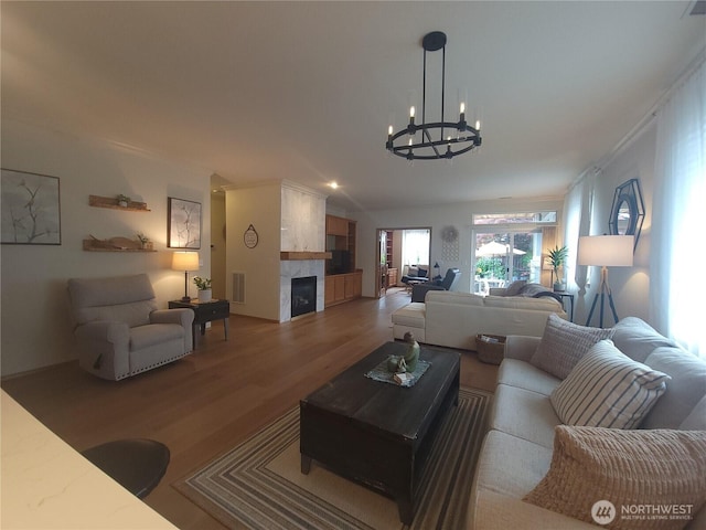 8542 Bainbridge Loop NE, Lacey, WA 98516 - living area with a chandelier, wood finished floors, a high end fireplace, and vaulted ceiling