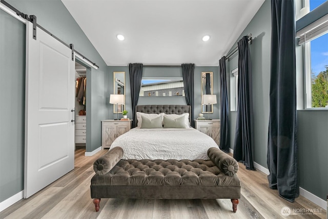 2649 Sandwood Ln, Blaine, WA 98230 - bedroom featuring a barn door, wood finished floors, a spacious closet, recessed lighting, and lofted ceiling
