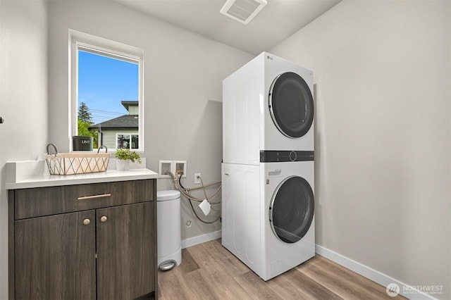 2649 Sandwood Ln, Blaine, WA 98230 - laundry area with estacked washer and dryer, light wood-type flooring, and cabinet space