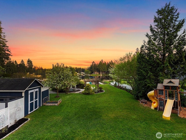 31707 W Lake Ketchum Rd, Stanwood, WA 98292 - yard at dusk with a playground, a storage shed, and a lawn