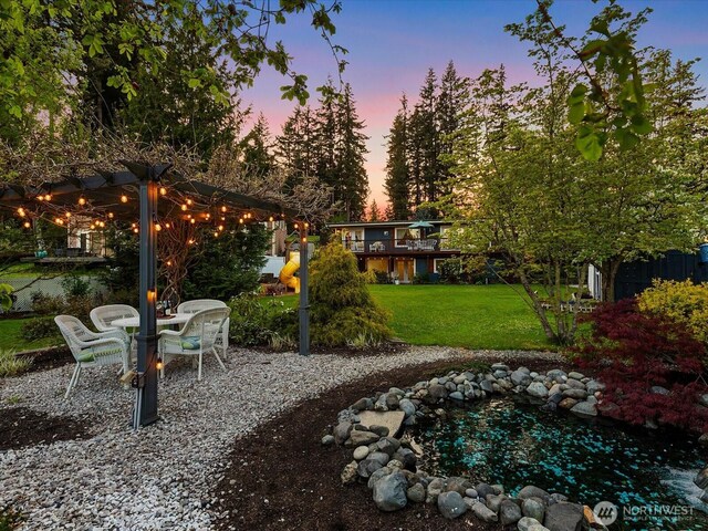 31707 W Lake Ketchum Rd, Stanwood, WA 98292 - yard at dusk with a yard, a patio, and a pergola