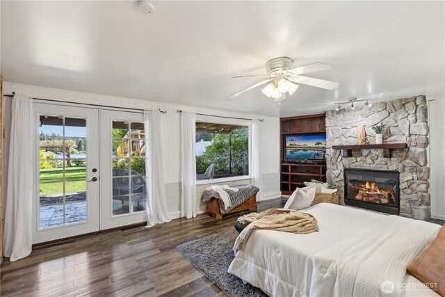 31707 W Lake Ketchum Rd, Stanwood, WA 98292 - bedroom featuring access to exterior, french doors, wood finished floors, a stone fireplace, and a ceiling fan