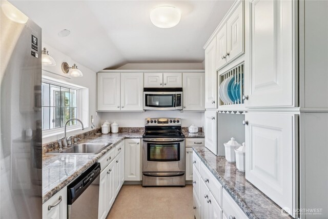 4448 S Shore Dr, Anacortes, WA 98221 - kitchen with appliances with stainless steel finishes, lofted ceiling, white cabinets, and light stone countertops