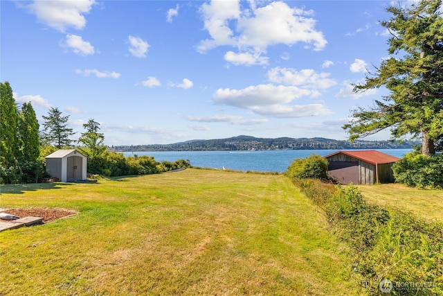 4448 S Shore Dr, Anacortes, WA 98221 - view of grassy yard featuring a storage unit and a water view