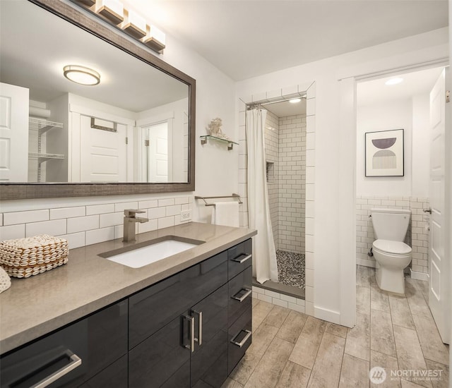 2301 Fairview Ave E Unit 301, Seattle, WA 98102 - full bathroom featuring vanity, wood finished floors, a stall shower, and tile walls