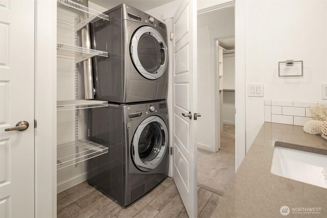 2301 Fairview Ave E Unit 301, Seattle, WA 98102 - washroom with stacked washer / drying machine and light wood-style flooring