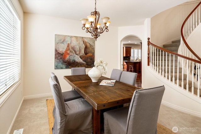 1206 S 36th Pl, Renton, WA 98055 - carpeted dining room with arched walkways, stairs, and a chandelier