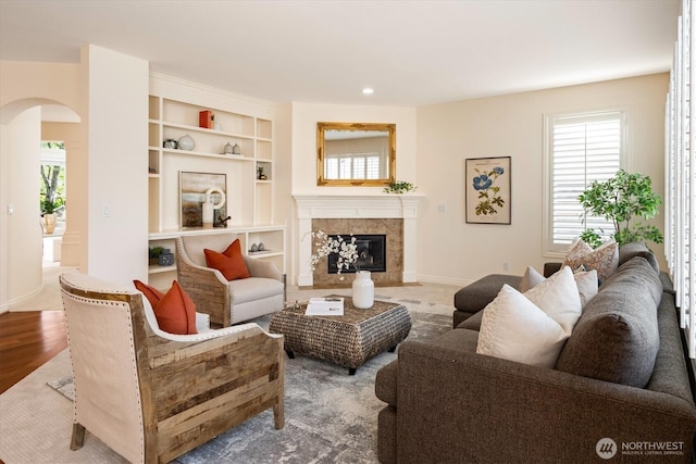 1206 S 36th Pl, Renton, WA 98055 - living room featuring arched walkways, a premium fireplace, built in shelves, wood finished floors, and recessed lighting