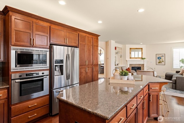 1206 S 36th Pl, Renton, WA 98055 - kitchen with appliances with stainless steel finishes, open floor plan, dark wood-style flooring, a center island, and recessed lighting