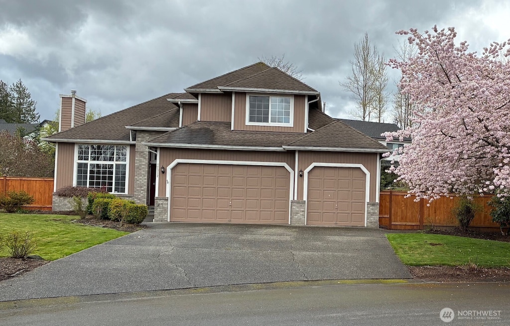 12312 9th St E, Edgewood, WA 98372 - view of front facade with an attached garage, driveway, a chimney, and roof with shingles