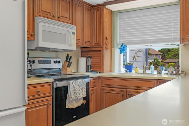 1541 Sheridan Unit C2, Bremerton, WA 98310 - kitchen with white microwave, freestanding refrigerator, electric range, light countertops, and brown cabinets