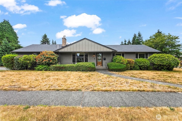 5620 N 23rd St, Tacoma, WA 98406 - ranch-style home with a chimney, a front lawn, and board and batten siding