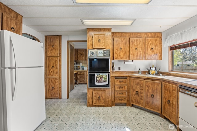 2641 Scotlac Dr SW, Olympia, WA 98512 - kitchen featuring white appliances, brown cabinetry, and light countertops