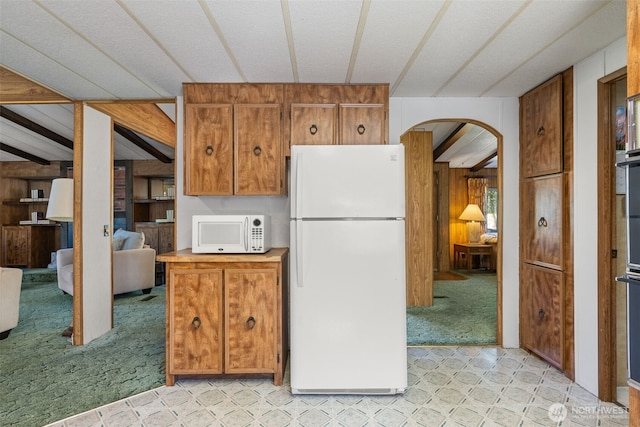 2641 Scotlac Dr SW, Olympia, WA 98512 - kitchen featuring white appliances, arched walkways, brown cabinets, light colored carpet, and wood walls