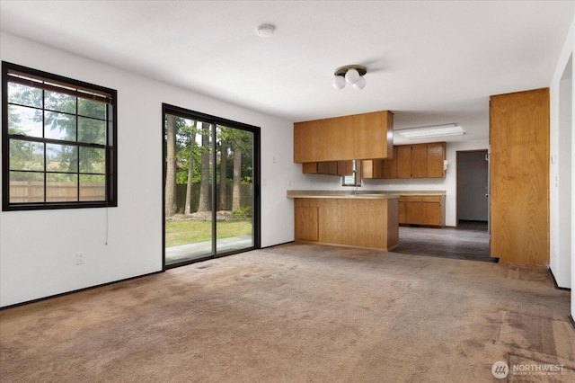 1078 NW Kitsap Ter, Oak Harbor, WA 98277 - kitchen with brown cabinets, a peninsula, light countertops, and healthy amount of natural light