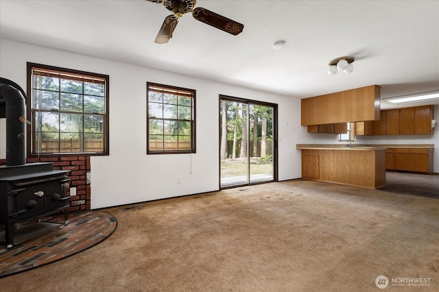 1078 NW Kitsap Ter, Oak Harbor, WA 98277 - unfurnished living room featuring a wood stove, carpet floors, and ceiling fan