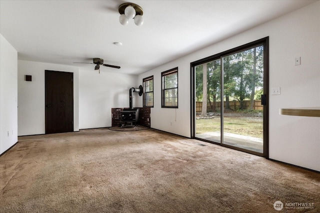1078 NW Kitsap Ter, Oak Harbor, WA 98277 - unfurnished living room featuring a wood stove, carpet flooring, and ceiling fan