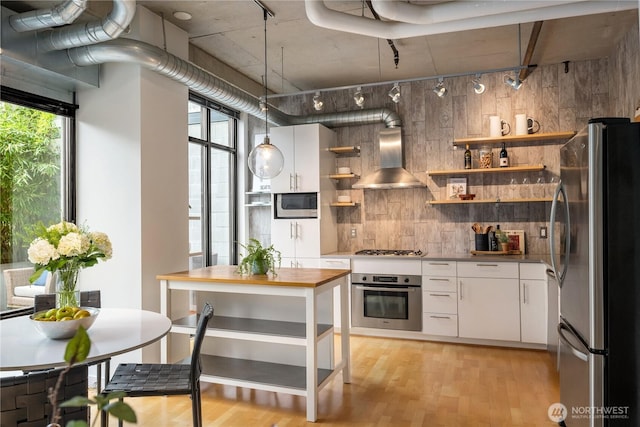 2720 3rd Ave Unit 412, Seattle, WA 98121 - kitchen featuring stainless steel appliances, open shelves, island range hood, white cabinetry, and light wood-style floors