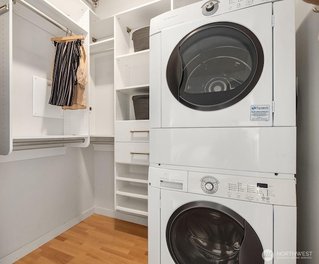 2720 3rd Ave Unit 412, Seattle, WA 98121 - washroom featuring stacked washer / dryer and light wood finished floors