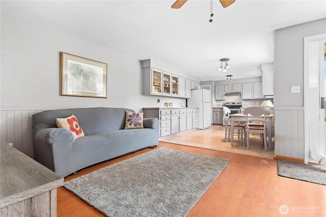 8374 W Meadow Ln, Lynden, WA 98264 - living area featuring a wainscoted wall, a ceiling fan, and light wood finished floors