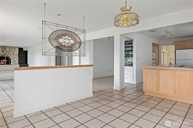 5017 Harbor Hills Dr, Freeland, WA 98249 - kitchen featuring white appliances, open floor plan, a stone fireplace, light tile patterned floors, and a chandelier