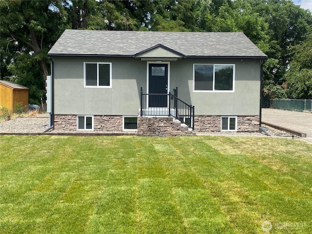 604 SW 4th St, College Place, WA 99324 - view of front of house with a front lawn, roof with shingles, stucco siding, and an outbuilding