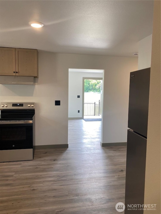 604 SW 4th St, College Place, WA 99324 - kitchen with stainless steel electric range oven, freestanding refrigerator, and wood finished floors