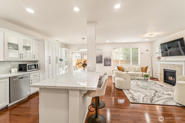 17710 39th Ave SE, Bothell, WA 98012 - kitchen with appliances with stainless steel finishes, open floor plan, a breakfast bar area, white cabinets, and dark wood-style flooring