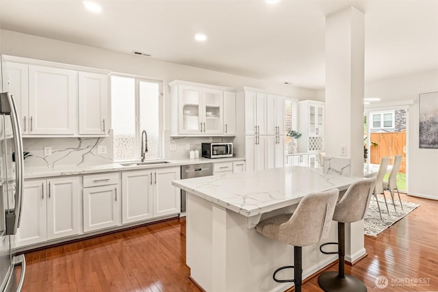17710 39th Ave SE, Bothell, WA 98012 - kitchen with white cabinets, appliances with stainless steel finishes, wood-type flooring, light stone counters, and recessed lighting